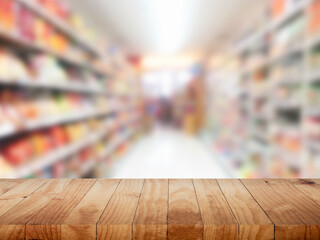 Wood table top with supermarket grocery store blurred background with bokeh light for product display