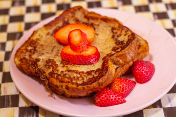 deliciosa tostada francesa con guarnición de fresa por encima, ligeramente rociada con miel por encima, comida sana en casa