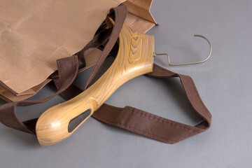 Beige modern plastic clothes hanger in a cloth bag on the table.