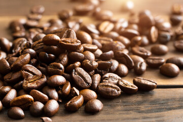 Roasted coffee beans close - up-fragrant background. Brown arabica coffee beans are scattered on the wooden table. Copy space