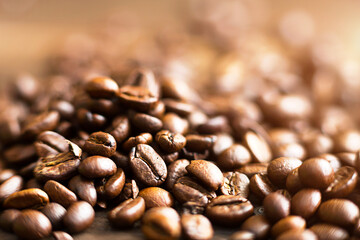 Roasted coffee beans close - up-fragrant background. Brown arabica coffee beans are scattered on the wooden table. Copy space