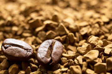 Beans of natural roasted coffee close-up lie on the granules of instant coffee. Ingredients of a...