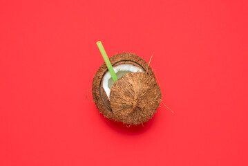 Coconut isolated on a red background. Cracked coconut top view.