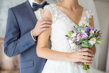 Obraz na płótnie Canvas wedding bouquet and newlyweds hands