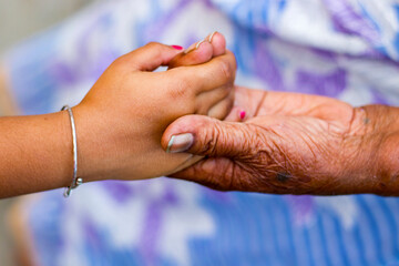 a grandmother holding hand of her granddaughter.