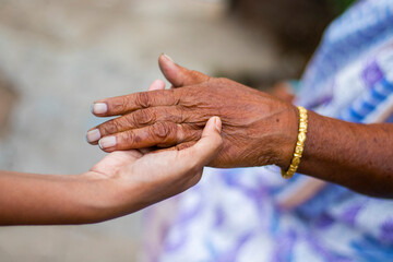 a grandmother holding hand of her granddaughter.