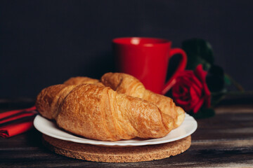 two croissants on a plate a cup of coffee wooden table dessert meal