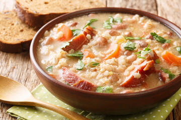 Homemade Ricet barley and bean soup with smoked meat and vegetables close-up in a bowl. horizontal