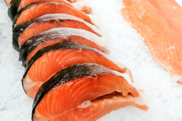 Salmon trim and steaks. Fresh raw salmon fish slices on white ice background