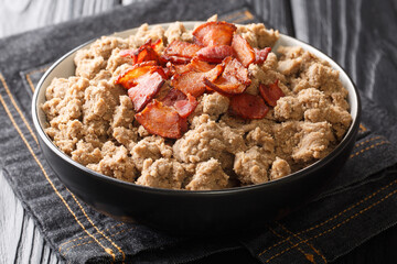 Rustic style Ajdovi zganci Slovenian buckwheat porridge served with cracklings close-up in a bowl on the table. horizontal