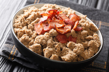 Slovenian buckwheat porridge served with cracklings close-up in a bowl on the table. horizontal
