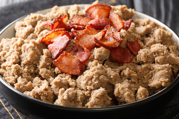 Tasty Ajdovi zganci made from buckwheat flour and fried bacon close-up in a bowl on the table. horizontal