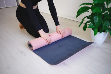 female hands unfold yoga mat preparing for practice