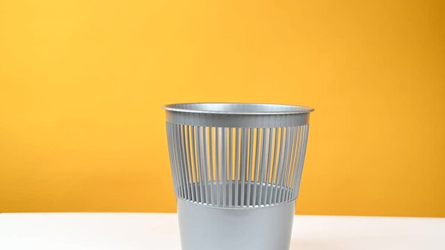 Hand throws glasses into the trash can