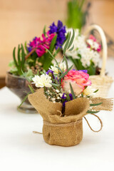 Beautiful flower arrangement in a pot wrapped in burlap.