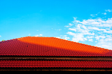 New red metal tiled roof house roofing construction exterior texture.
