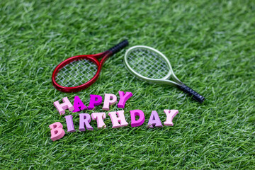 Happy birthday to tennis player with tennis racket on green grass
