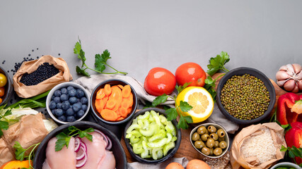 Selection of organic raw healthy products on gray background product.