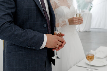 groom holding champagne glasses