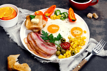 Fried eggs with vegetables on dark grey background