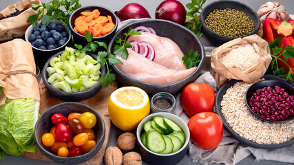 Selection of organic raw healthy products on gray background product.