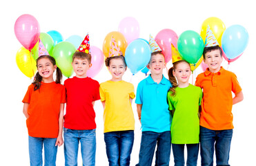 Group of children in colored t-shirts and party hats.