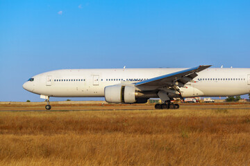 Big passenger airplane drives along the runway in airport