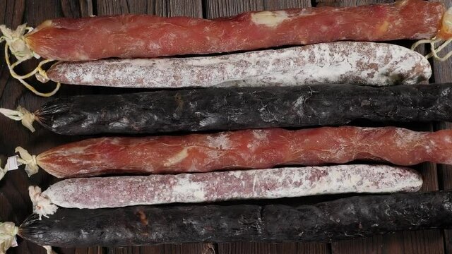 Close-up of set of different dry sausages on a wooden background. Spanish salami