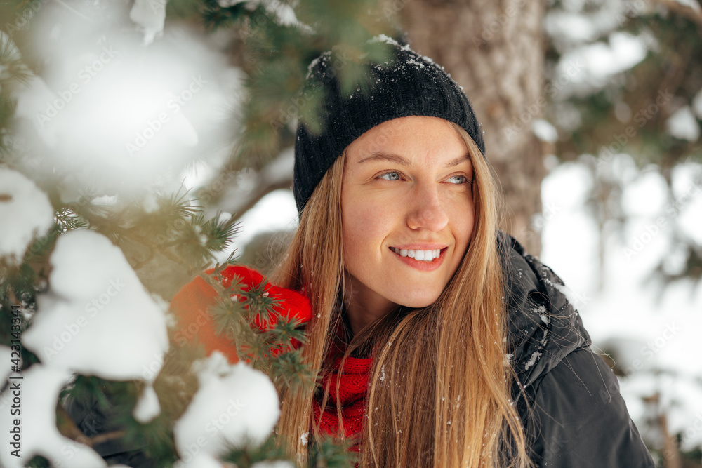 Wall mural happy smiling young woman having fun with snow in a winter park