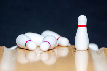 Naklejka premium Bowling. One unbroken pin in white on the bowling lane. Black background. Copy space. Space for text