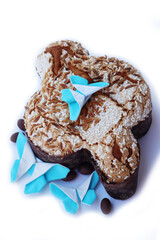 Sweet Easter cake called Colomba Pasquale on white with fabric butterflies decorations and chocolate eggs. Italian traditional pastry 