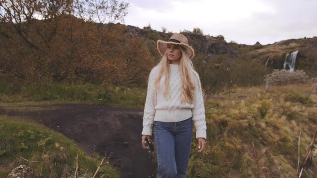 Blond Woman Walking In Icelandic Countryside