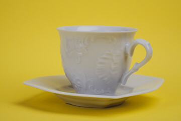 White teacup on a yellow background