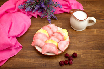 pink and yellow sweet dumplings with fruit and a glass of milk Traditional cuisine. Semi-finished products. Varenyky. Traditional dish of Central and Eastern Europe