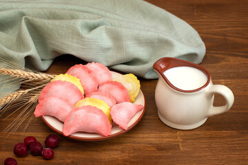 Bright, colored dumplings with cherries and a glass of milk for baby food. Traditional cuisine.
