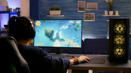Esport video game r wearing headset and playing online video game for space shooter championship....