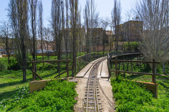 Image of an iron bridge of the Catalonia park train with the tracks of a scale train for passengers with a fence closed to the public in (Catalonia, Spain)