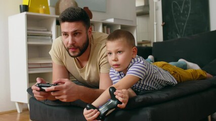 father playing video games with his son at home - Powered by Adobe
