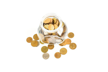 Metal coins in a glass jar isolated on a white background. Keeping personal savings. Financial crisis, ruble devaluation. Copy space for text. Selective focus.