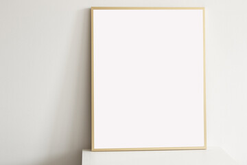 empty minimal style golden vertical frame on white table with white wall on the background