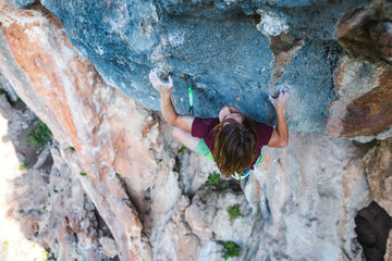 A young athlete climbs a rock