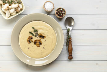 Plate of delicious mushroom cream soup with thymes on the wooden table. Horizontal top view from...