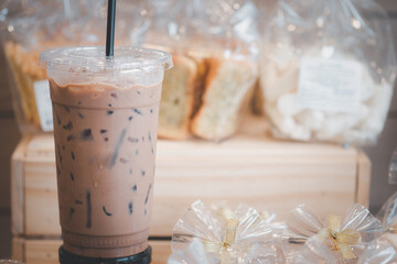 Iced Mocha coffee placed on shelf cookies and bread in plastic bags.