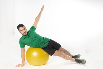 man exercising with fitball on white background