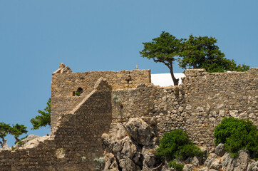 Fortress wall of the medieval Monolithos castle illuminated by the sun closeup (Rhodes, Greece)