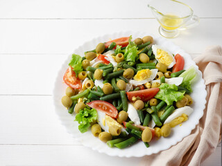 A plate of salad with vegetables and herbs
