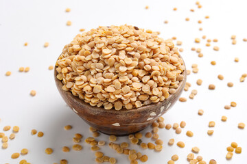 Unpolished Pigeon pea also known as toor dal in a bowl. Isolated on white background.