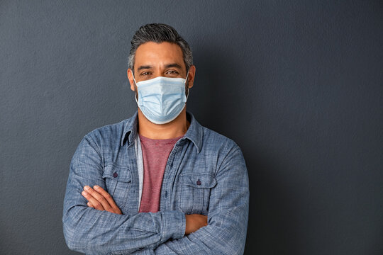 Happy Middle Eastern Man Wearing Protective Face Mask On Grey Wall With Copy Space