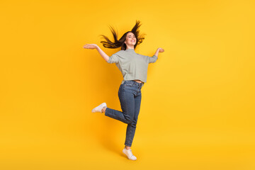Fototapeta na wymiar Full length body size view of attractive cheerful girl jumping having fun rest good mood isolated over bright yellow color background
