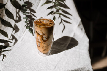 glass of coffee with milk on a white canvas